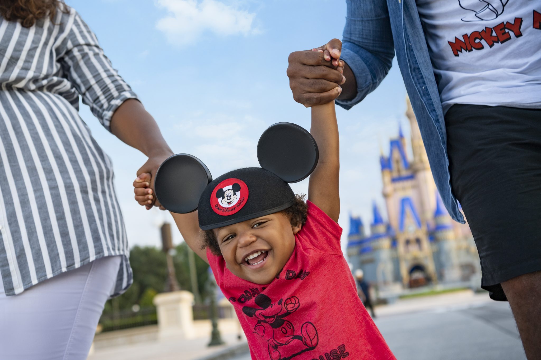 A happy young toddler with Cinderella castle in the background