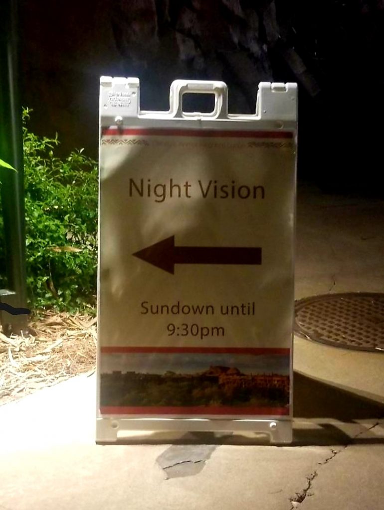 A sign indicating where to pick up night vision goggles at Animal Kingdom Lodge
